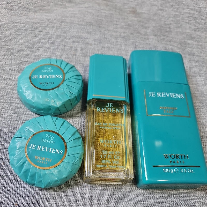 Worth Paris 'Je Reviens' perfume set on a textured gray surface