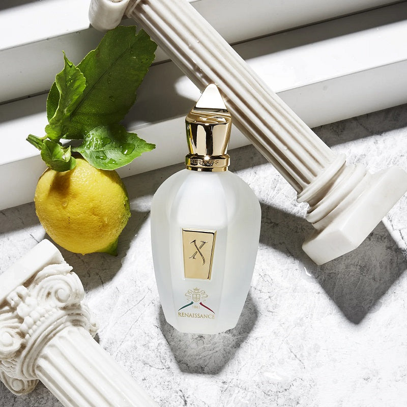 White bottle with gold cap and decorative elements on a textured surface