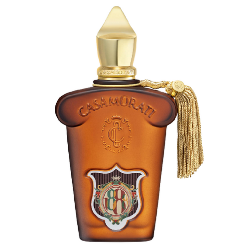 Casamorati cologne bottle in amber glass with a gold cap, gold tassel, and an ornate crest emblem on the front, set against a plain white background.