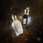 Two perfume bottles, one white and one black with gold accents, on a dark background.