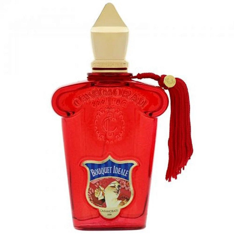 A red glass bottle of Casamorati Bouquet Ideale Eau de Parfum by Xerjoff with a white cap and a red tassel.