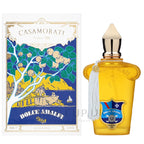 The product image shows two views of a perfume bottle. On the left is the packaging with a colorful illustration of a Mediterranean scene, and on the right is the perfume bottle itself with a yellow liquid inside.