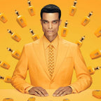 Man in an orange suit with matching tie and background featuring orange bottles.