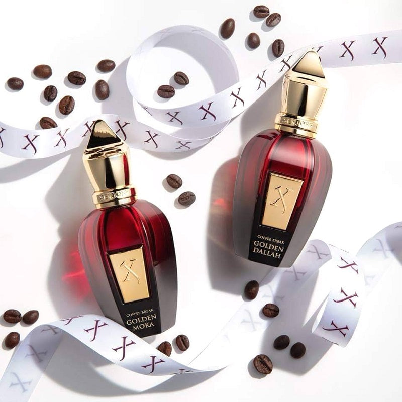 Two red perfume bottles with gold caps on a white background with coffee beans.
