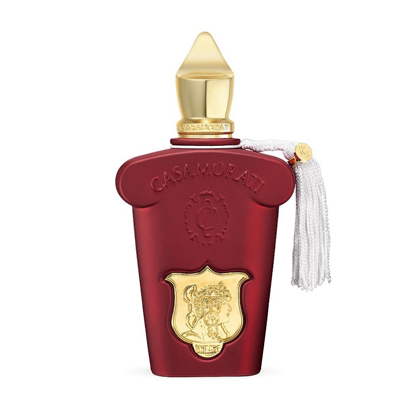 A glass bottle of Casamorati Italica Eau de Parfum by Xerjoff with a red label, a gold-colored cap, and a white tassel.