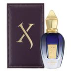 Perfume bottle with gold cap and blue body next to a dark purple leather case with a gold 'X' on a white background