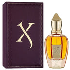 La Capitale Perfume bottle with gold cap and 'X' logo next to a purple box with 'X' logo