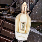 Perfume bottle with gold and white design on a dark, textured background