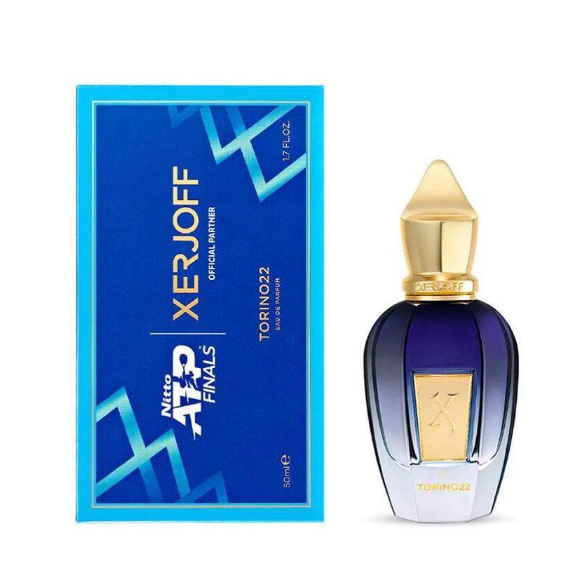 Perfume bottle with gold cap and blue packaging next to its box on a white background