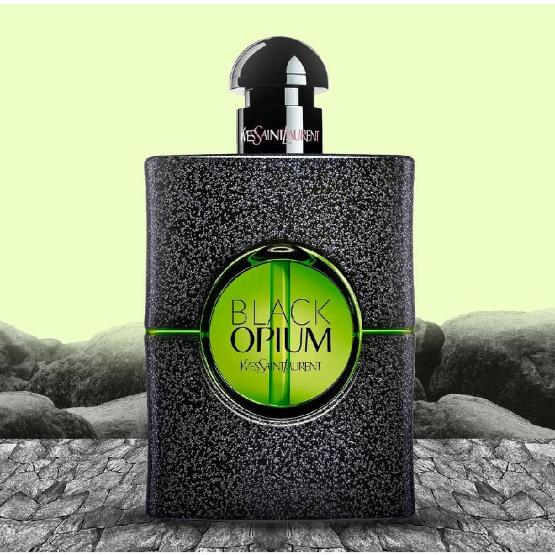 Yves Saint Laurent Black Opium perfume bottle on a textured surface with a light green background