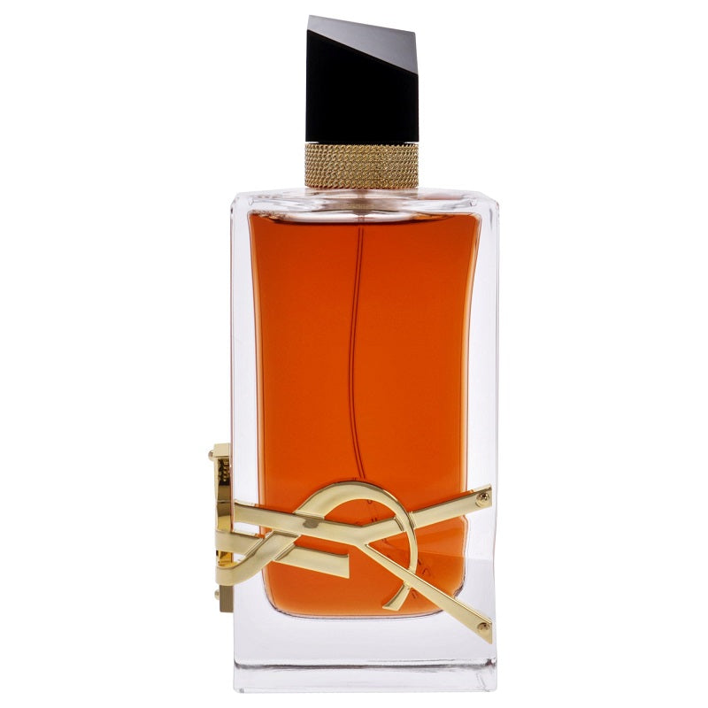 A glass bottle of Libre Le Parfum by Yves Saint Laurent with a gold design element, containing orange-colored liquid.