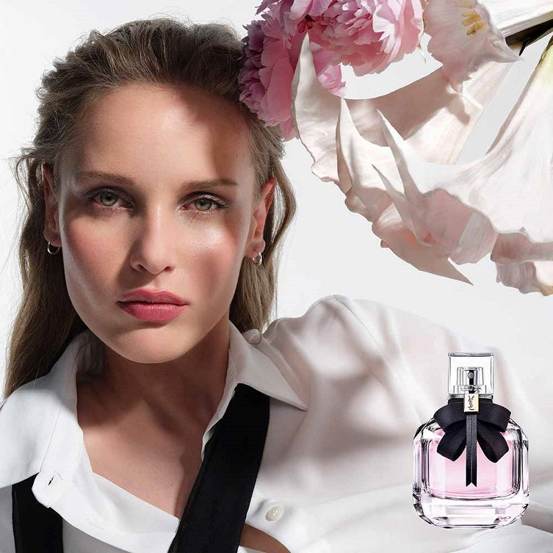 Woman with flowers and a perfume bottle in the foreground