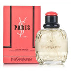 A photograph of Yves Saint Laurent's 'Paris' Eau de Toilette, featuring the perfume bottle with a clear liquid visible inside, alongside its pink packaging box.