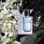 YSL perfume bottle with white flowers and water in the background
