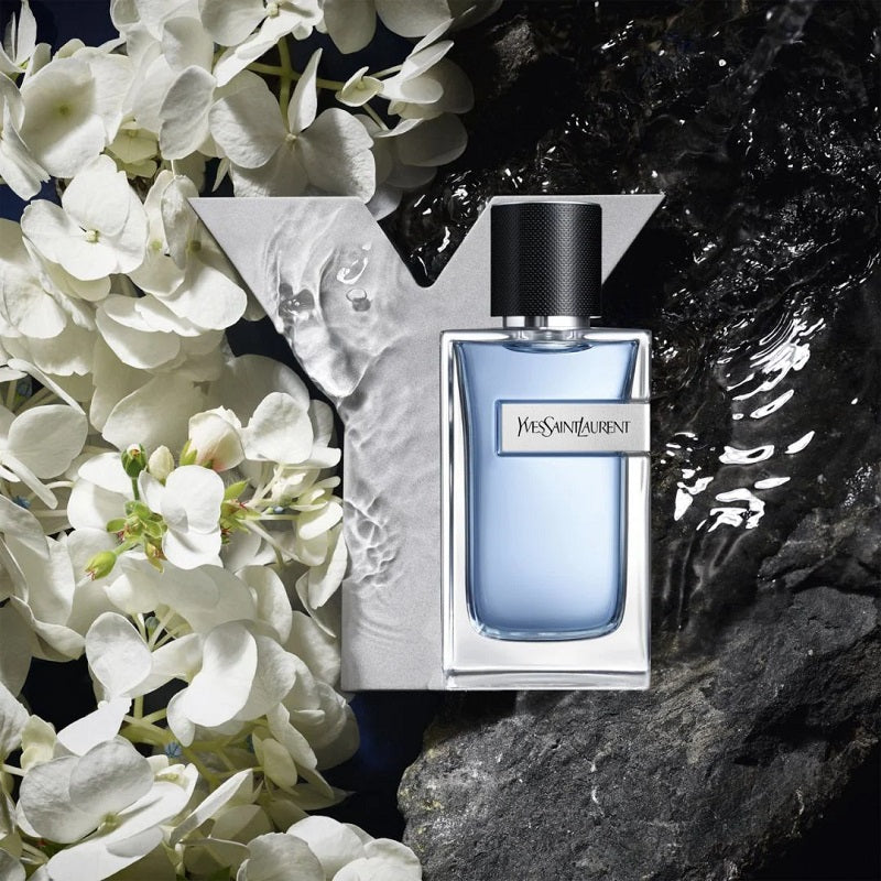 YSL perfume bottle with white flowers and water in the background