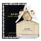 A product image featuring a 50ml bottle of Daisy Eau de Toilette by Marc Jacobs, with a white floral cap, displayed in front of its black packaging box.