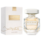 A bottle of 'Le Parfum In White' Eau de Parfum by Elie Saab, with a white cap and clear glass bottle, alongside its white box packaging with gold accents.