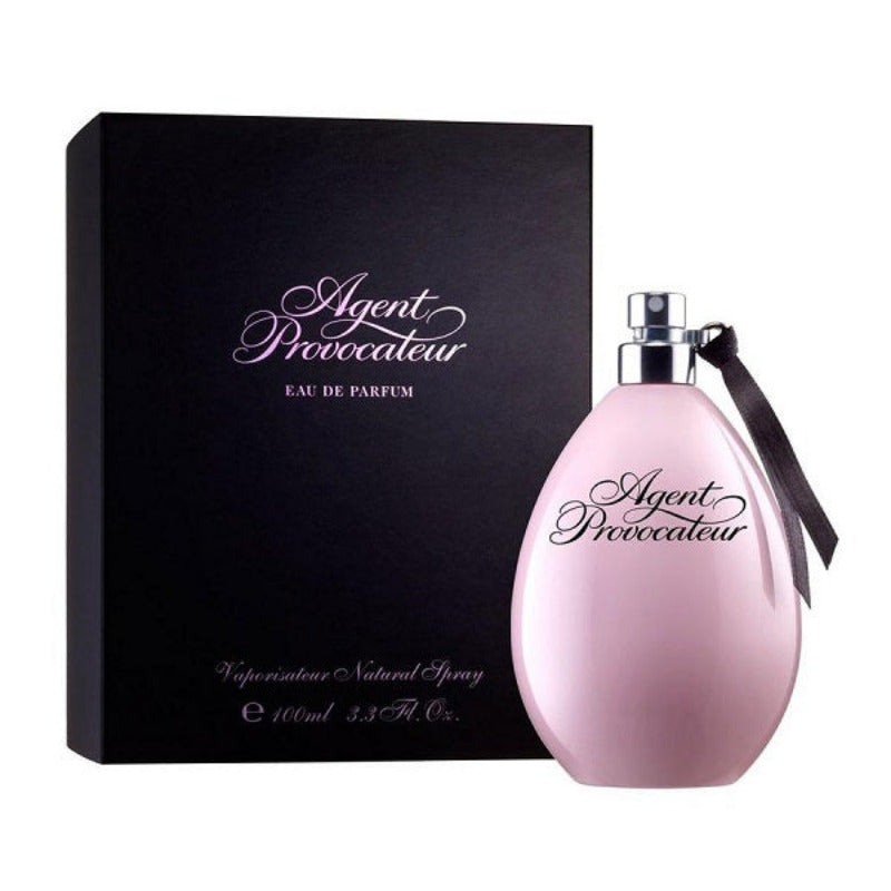 A bottle of Agent Provocateur Eau de Parfum with a pink hue and a black box packaging with the brand name and product title printed on it.