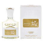 Aventus for Her Eau de Parfum by Creed in a white bottle with gold details, next to its packaging box.