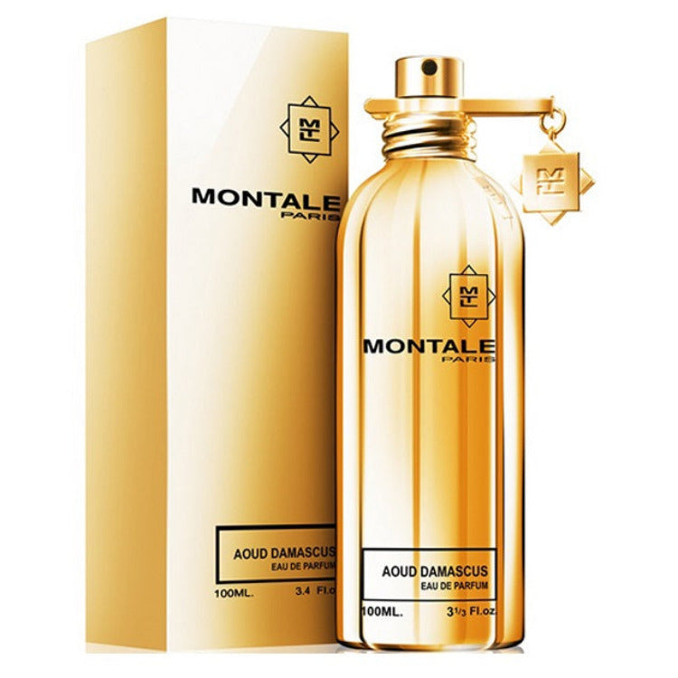 A gold-colored, transparent perfume bottle with a golden cap, labeled 'Montale Aoud Damascus Eau de Parfum 100ml'. The product is displayed alongside its packaging box.