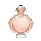 A glass bottle of Olympea Eau de Parfum by Paco Rabanne with a pink and amber liquid visible, along with a crystal-like cap.