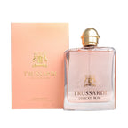 A bottle of Trussardi Delicate Rose eau de toilette next to its pink packaging box with gold accents.